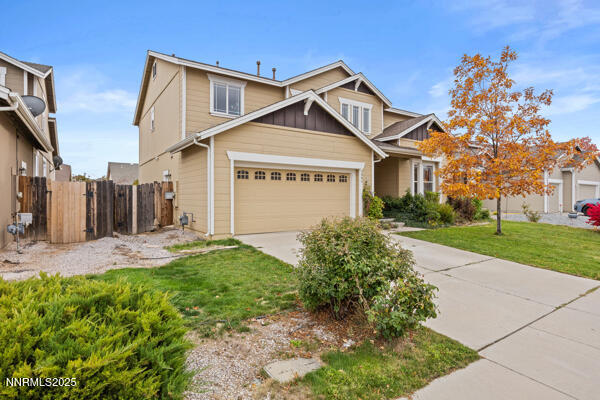 8994 Wynne Street Reno, NV 89506 - Photo 3 of 26 a view of a white house next to a yard with big trees