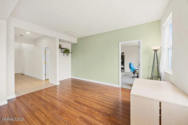 a view of a livingroom with wooden floor and furniture