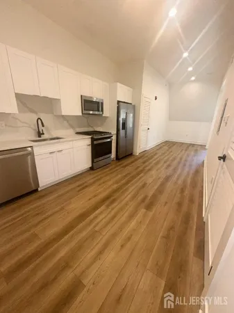 a kitchen with granite countertop a sink cabinets and stainless steel appliances