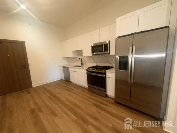 a kitchen with kitchen island a counter top space cabinets and stainless steel appliances