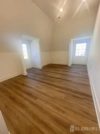 a view of empty room with window and wooden floor