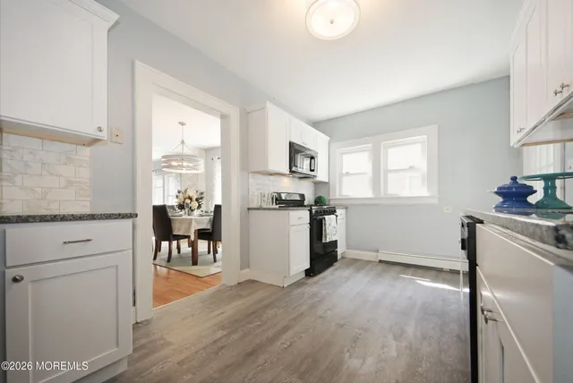 a kitchen with granite countertop white cabinets and white appliances