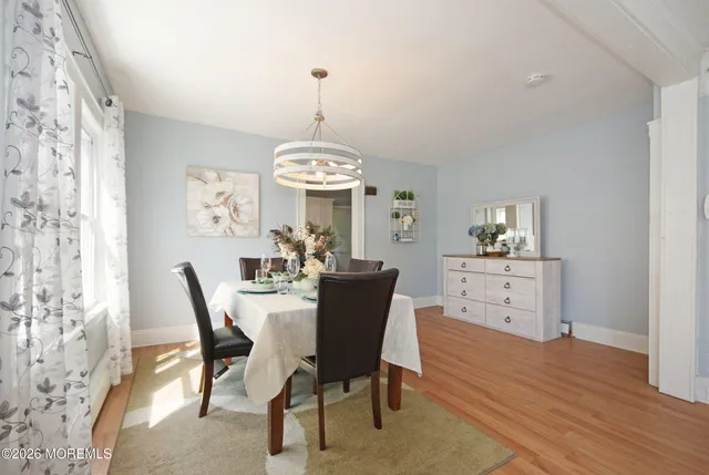 a view of a dining room with furniture a chandelier and wooden floor