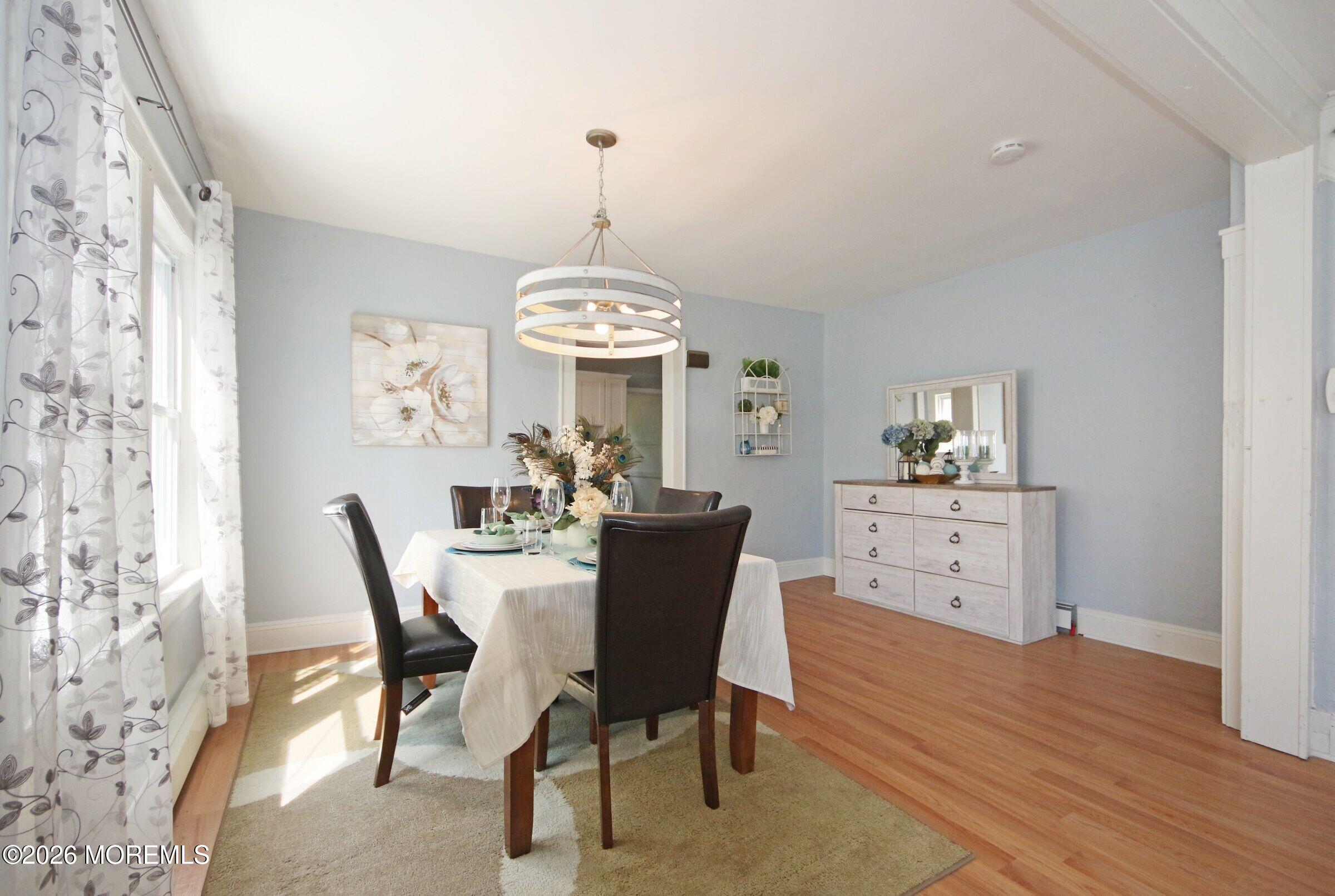 183 Ridge Avenue Asbury Park, NJ 07712 - Photo 10 of 23 a view of a dining room with furniture a chandelier and wooden floor