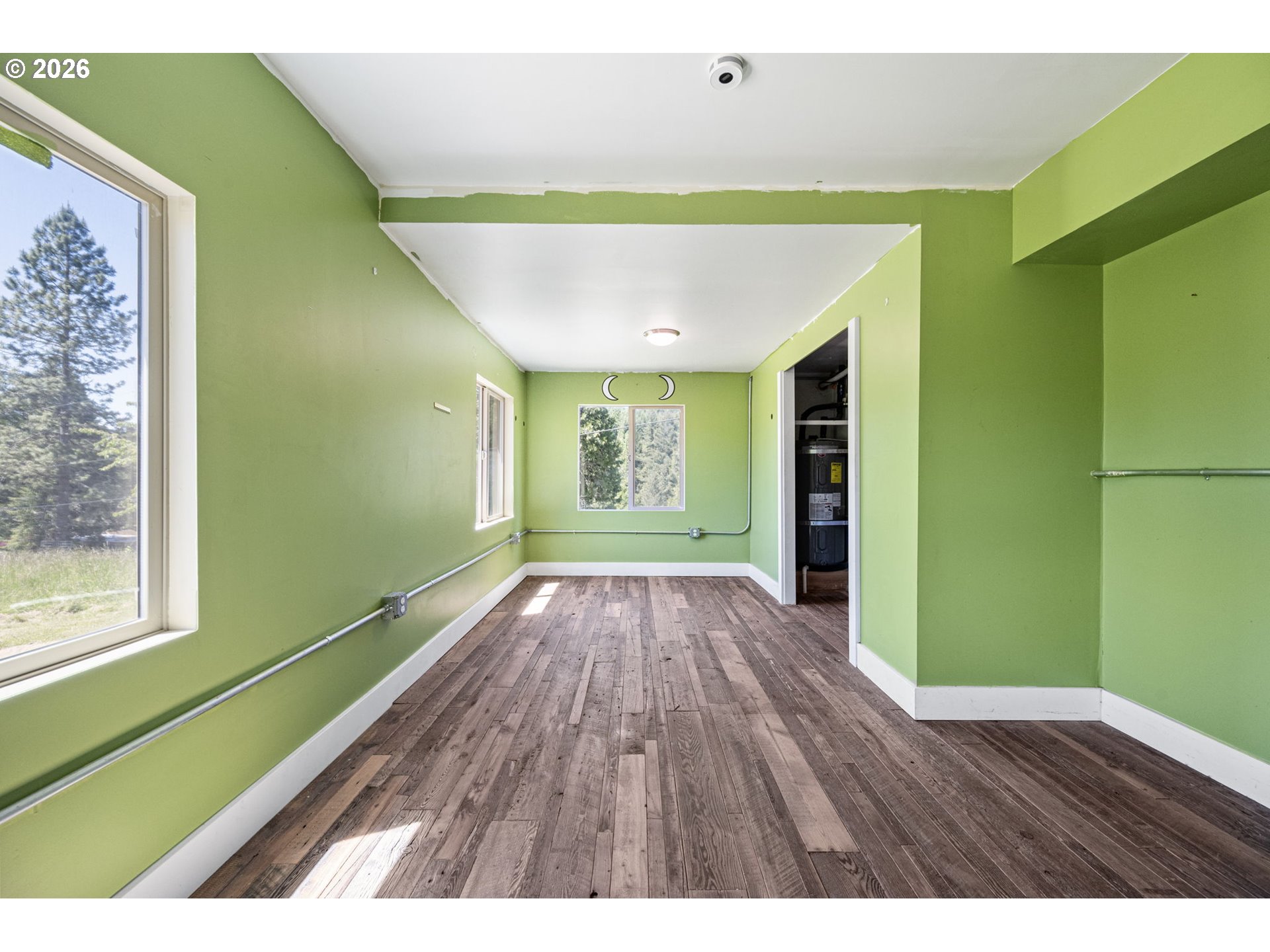77521 Brock Road Oakridge, OR 97463 - Photo 21 of 48 a view of an empty room with wooden floor and a window