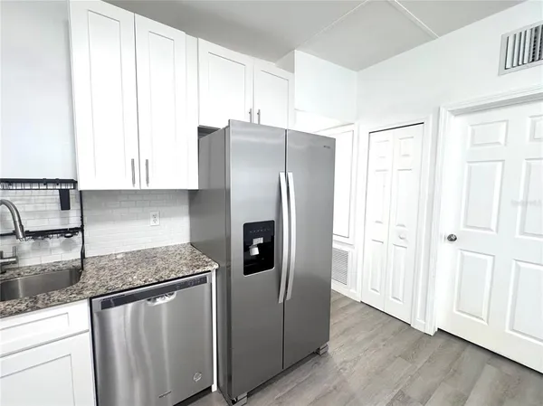 a kitchen with stainless steel appliances granite countertop a refrigerator and a stove