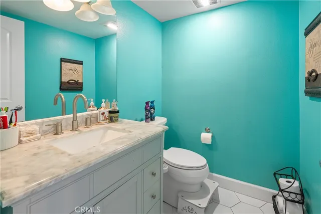 a bathroom with a granite countertop toilet and a sink