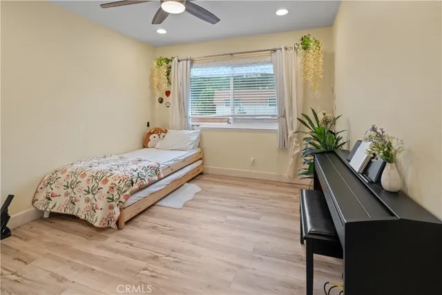a bedroom with a bed window and wooden floor