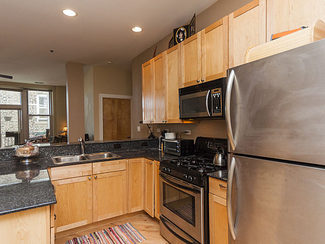 3113 West Lawrence Avenue, Unit D302 Chicago, IL 60625 - Photo 11 of 16 a kitchen with stainless steel appliances granite countertop a sink stove and microwave