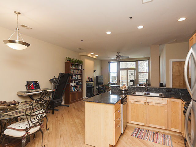3113 West Lawrence Avenue, Unit D302 Chicago, IL 60625 - Photo 12 of 16 a kitchen with stainless steel appliances kitchen island granite countertop a sink and cabinets