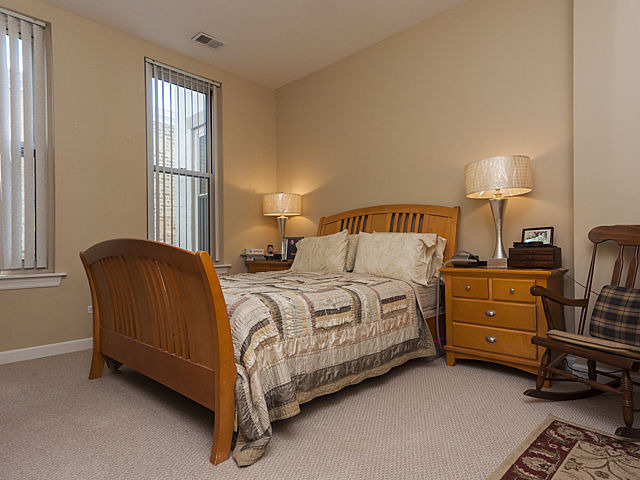 3113 West Lawrence Avenue, Unit D302 Chicago, IL 60625 - Photo 15 of 16 a bedroom with a bed and a window