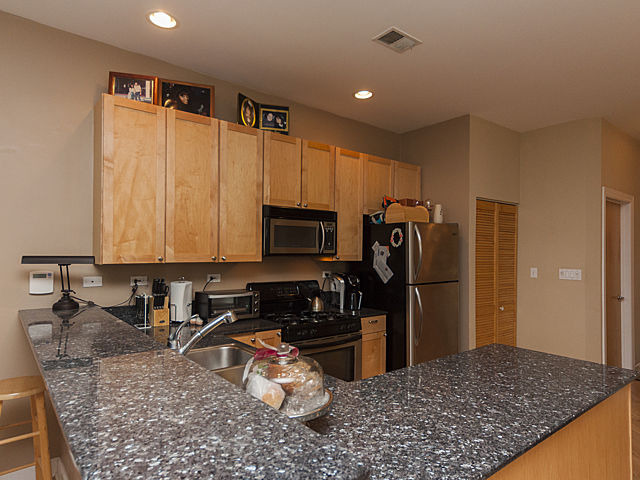 3113 West Lawrence Avenue, Unit D302 Chicago, IL 60625 - Photo 9 of 16 a kitchen with stainless steel appliances granite countertop a refrigerator sink and stove