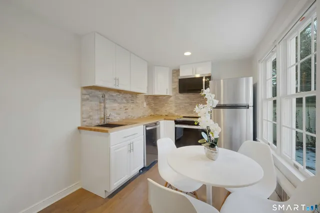a kitchen with white cabinets and stainless steel appliances