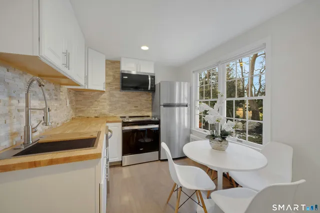 a kitchen with a sink a stove and chairs