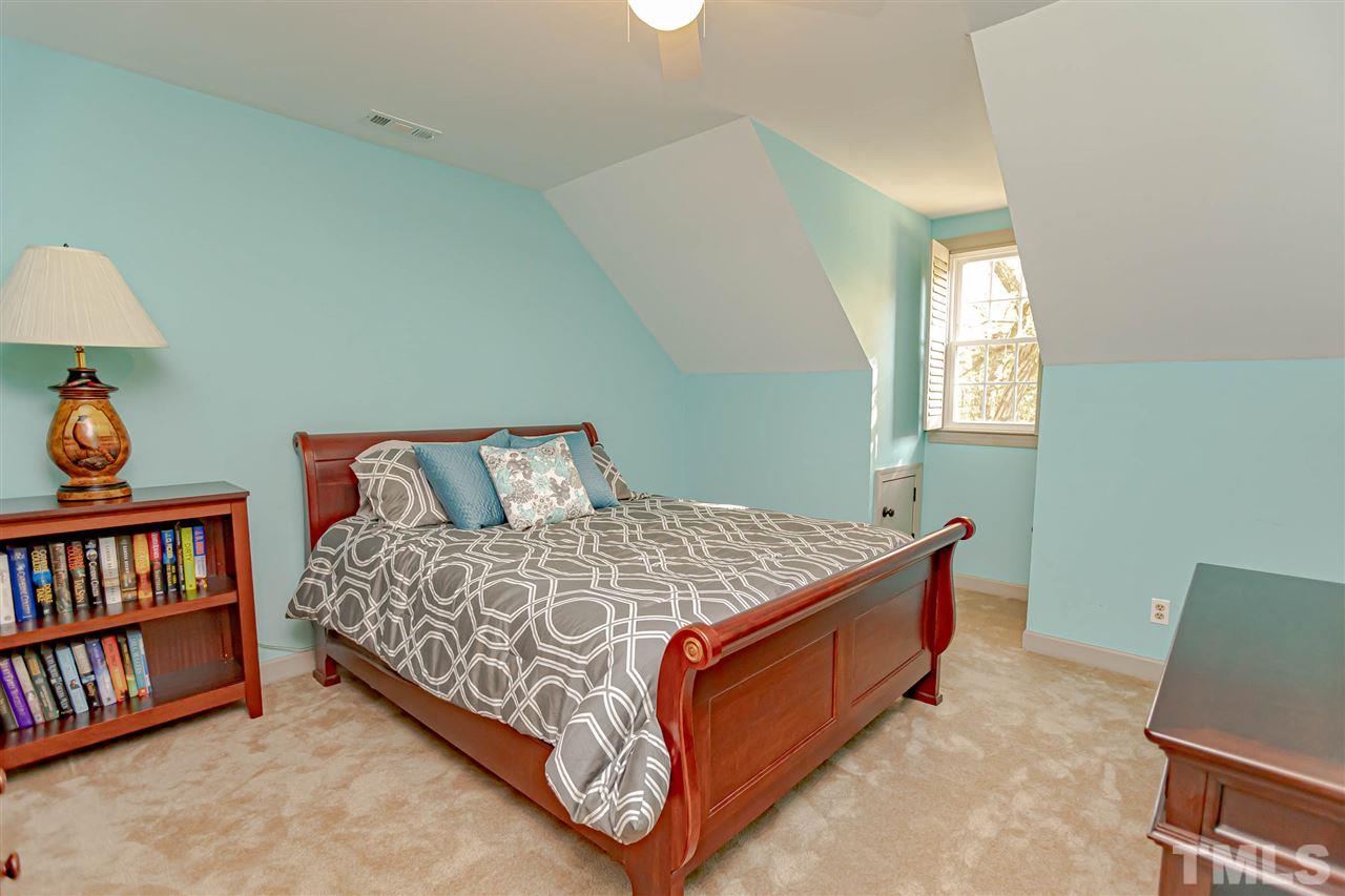 767 Weathergreen Drive Raleigh, NC 27615 - Photo 12 of 21 a bed sitting in a bedroom next to a book shelf
