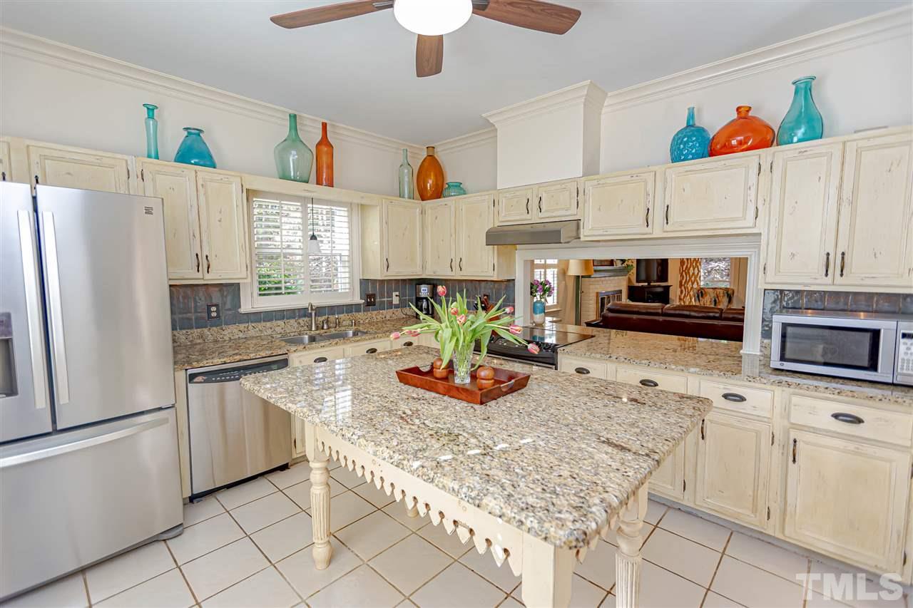 767 Weathergreen Drive Raleigh, NC 27615 - Photo 5 of 21 a kitchen with stainless steel appliances granite countertop a refrigerator sink stove and white cabinets
