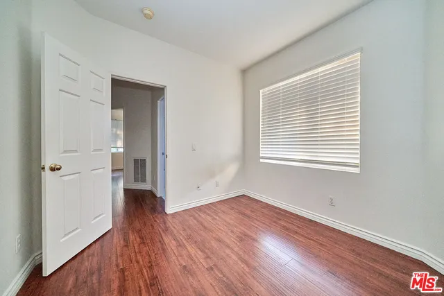 a view of a room with wooden floor and window