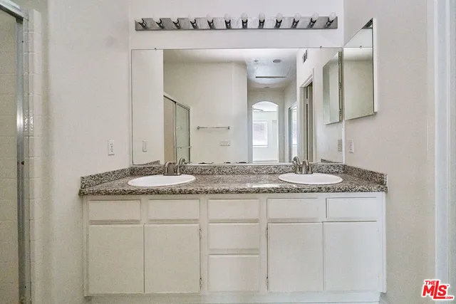 a bathroom with a granite countertop sink and a mirror
