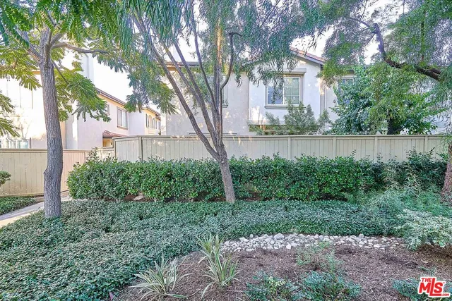 a view of a house with a yard and a large tree