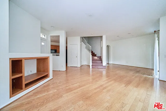 a view of empty room with wooden floor and fireplace