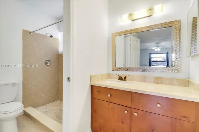 a bathroom with a granite countertop sink toilet and shower