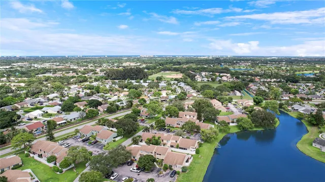 an aerial view of residential houses with outdoor space and trees