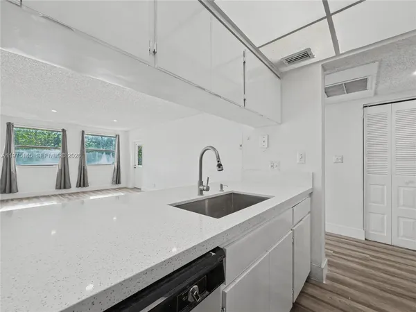 a view of a sink and dishwasher with wooden floor