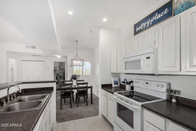 a kitchen with granite countertop a sink a stove and cabinets