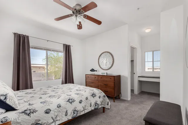 a bedroom with a bed a dresser and window