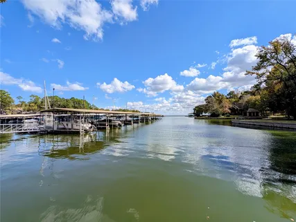 a view of swimming pool with outdoor seating and trees in the background