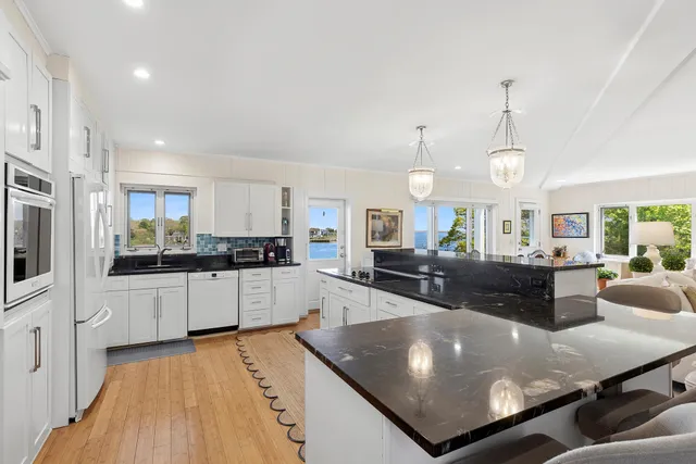 a large kitchen with kitchen island a large counter top stainless steel appliances and cabinets