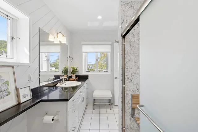 a bathroom with a granite countertop sink a mirror and a bathtub