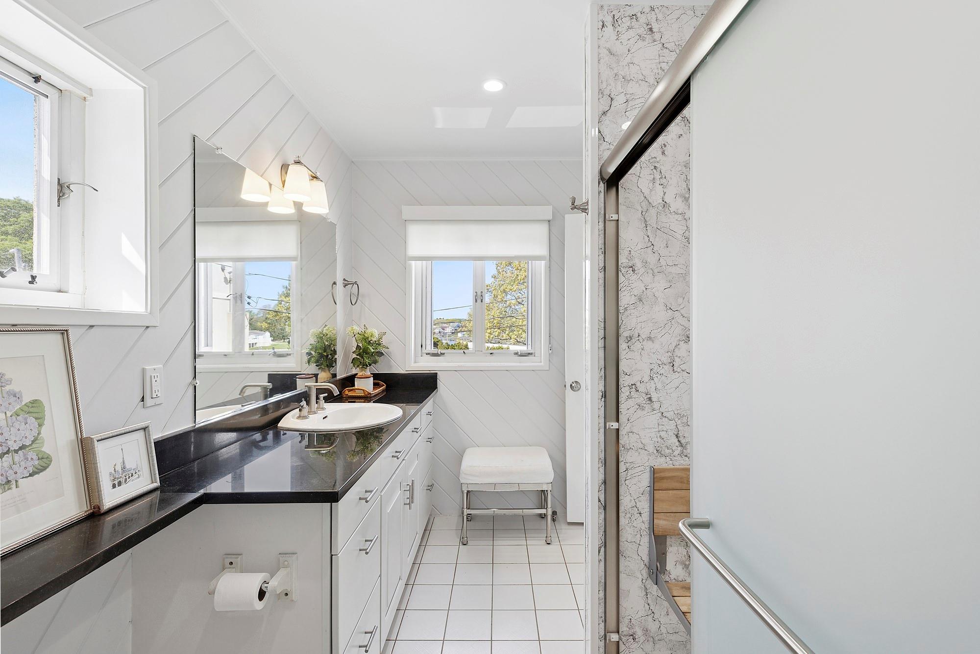 47 Rampasture Road, Unit M Hampton Bays, NY 11946 - Photo 11 of 17 a bathroom with a granite countertop sink a mirror and a bathtub
