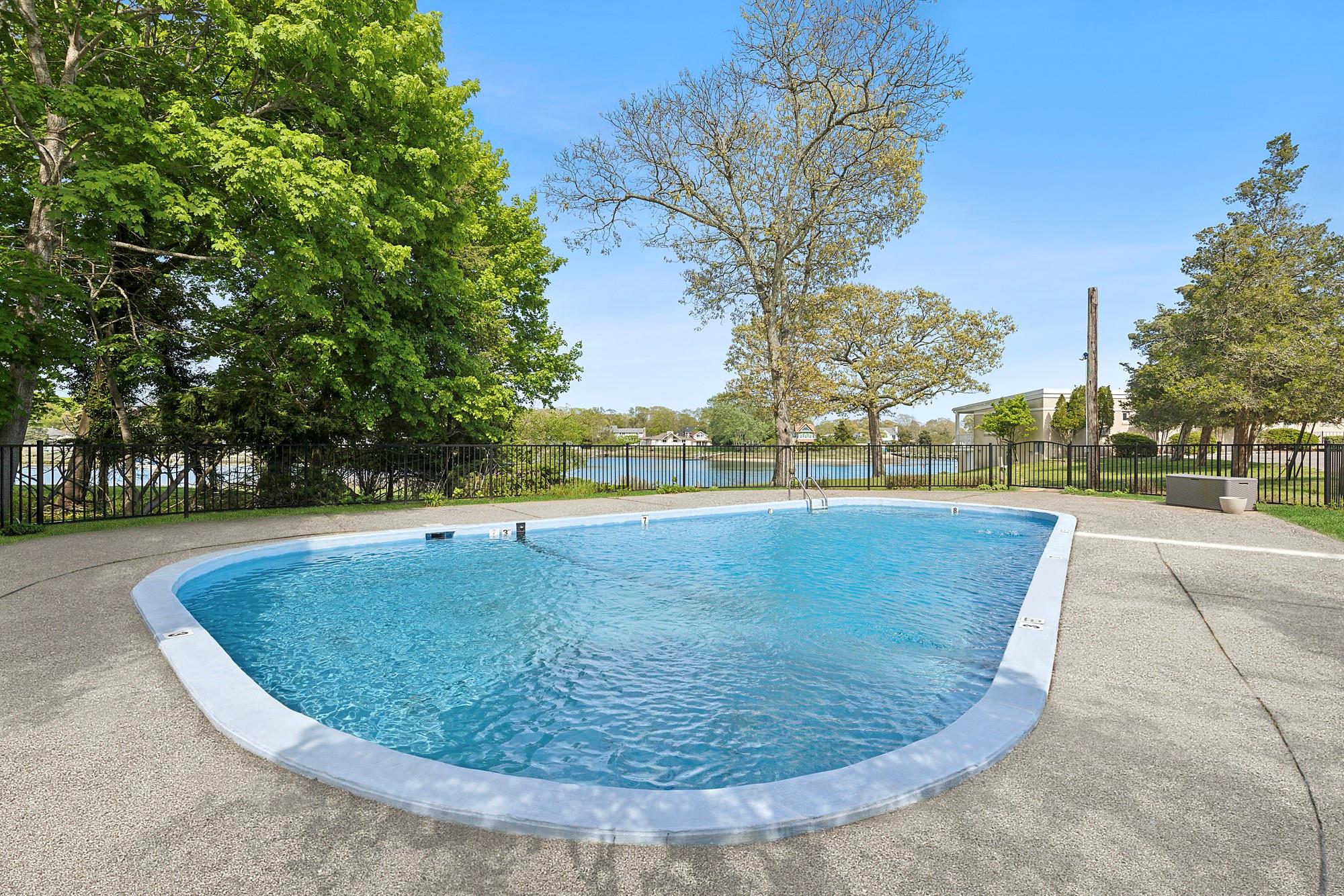47 Rampasture Road, Unit M Hampton Bays, NY 11946 - Photo 17 of 17 a view of a swimming pool with a yard