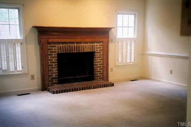 5209 Blakeley Lane Raleigh, NC 27613 - Photo 7 of 10 an empty room with a fireplace and windows