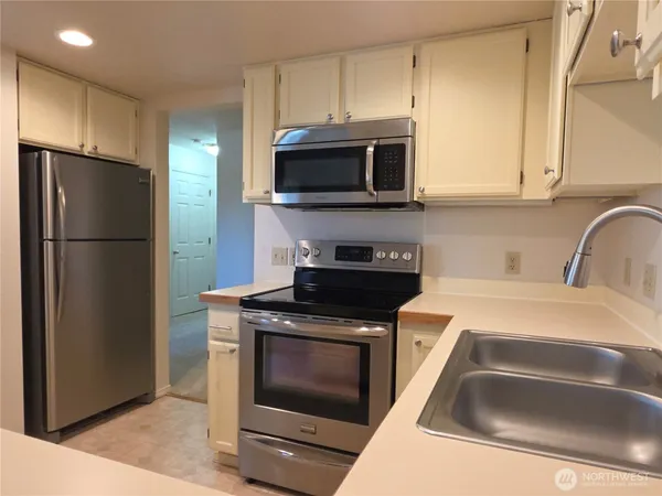 a kitchen with stainless steel appliances granite countertop a refrigerator stove and microwave