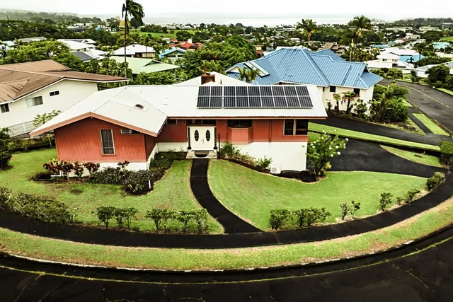 an aerial view of a house with a garden and lake view