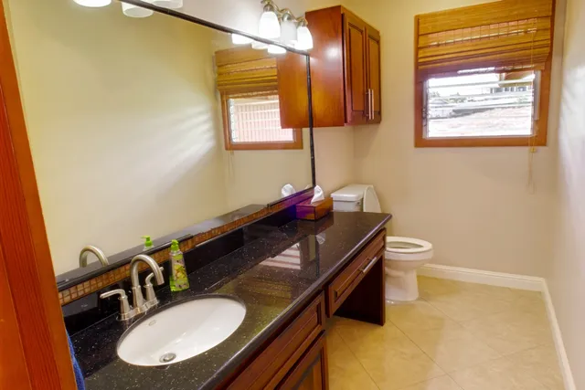 a bathroom with a granite countertop sink and a mirror