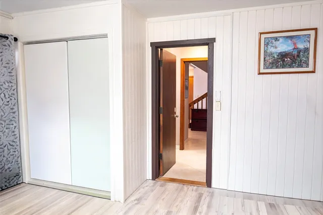 a view of a hallway with wooden floor and closet