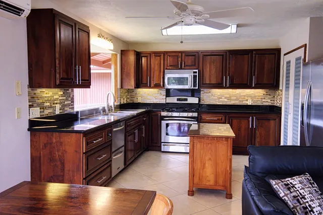 a kitchen with stainless steel appliances granite countertop a stove a sink and a microwave