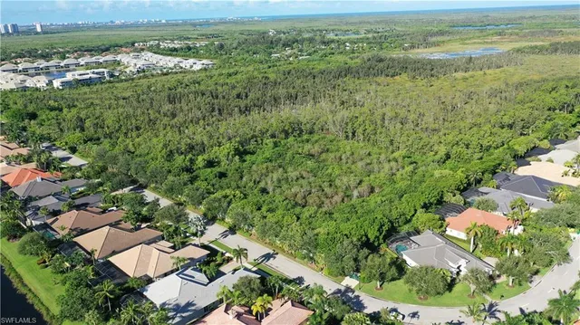 an aerial view of residential houses with outdoor space and trees