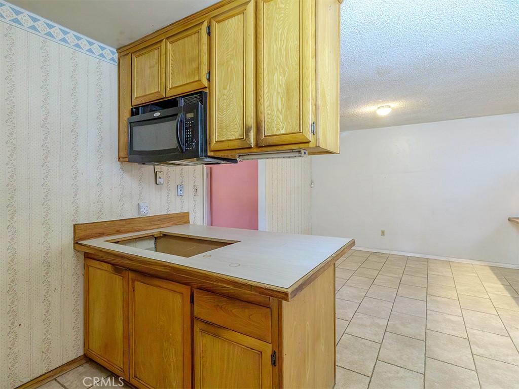 8815 San Vicente Avenue Riverside, CA 92503 - Photo 19 of 27 a kitchen that has a sink and a microwave oven in it