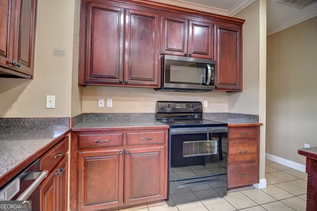a kitchen with granite countertop wooden cabinets and stainless steel appliances