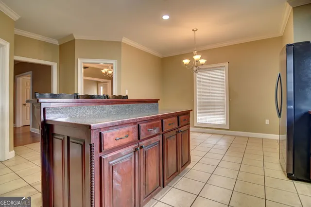 a view of kitchen with granite countertop cabinets and refrigerator