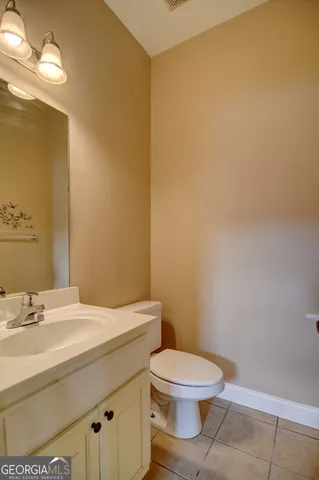 a bathroom with a granite countertop toilet and a sink