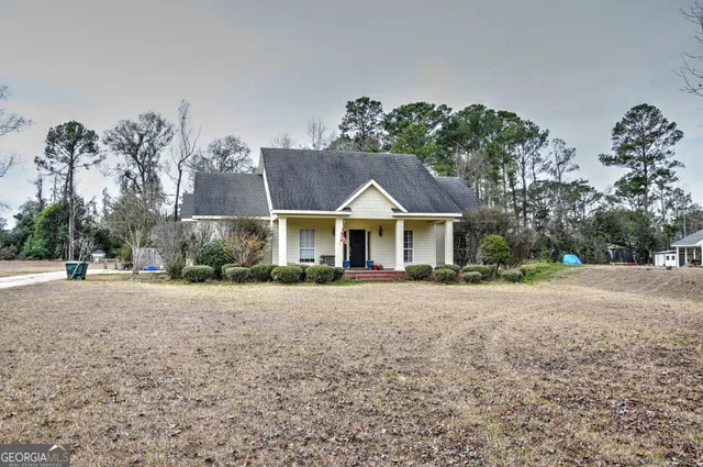 a front view of house with yard and trees in the background