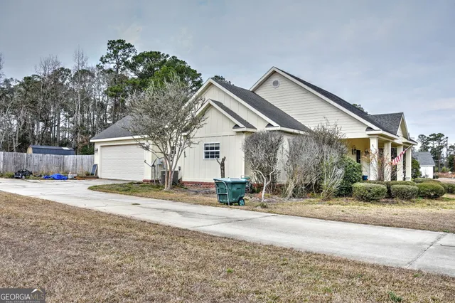 a view of a house with a yard and a large tree