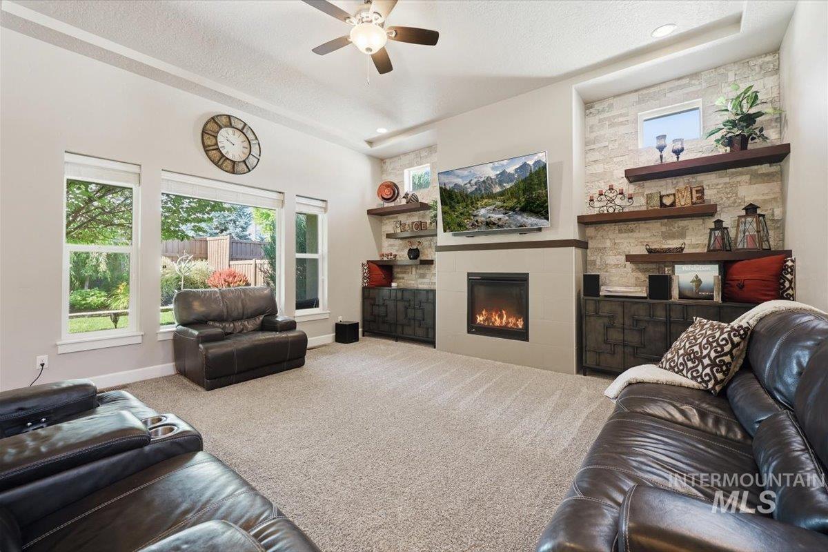 1303 West Brando Street Meridian, ID 83646 - Photo 21 of 49 Living area featuring a gas fireplace with a light-toned surround, flanked by built-in cabinetry with dark wood-finish doors