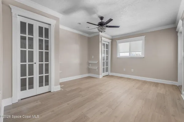 a view of an empty room with a window and wooden floor