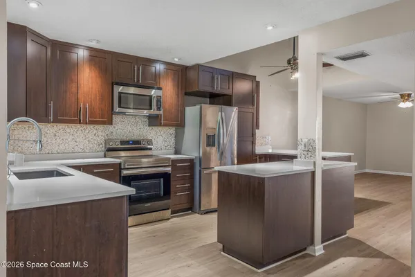 a kitchen with stainless steel appliances granite countertop a stove a refrigerator and a sink